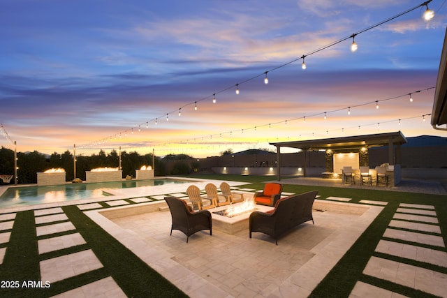 patio terrace at dusk featuring an outdoor fire pit, outdoor dry bar, and an outdoor pool