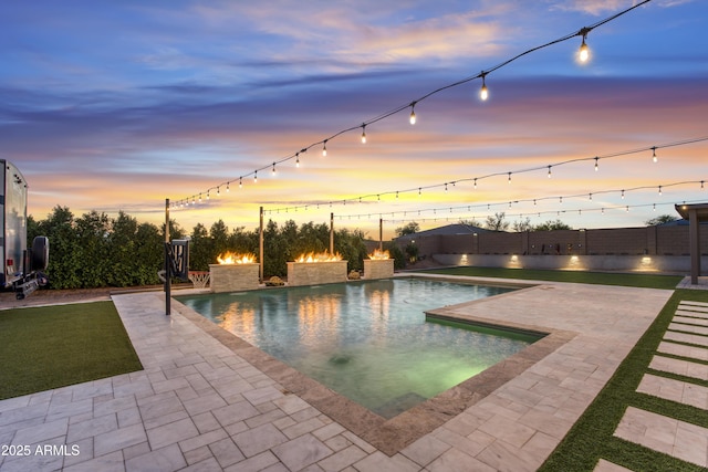 pool at dusk with a fenced in pool, a fenced backyard, and a patio area