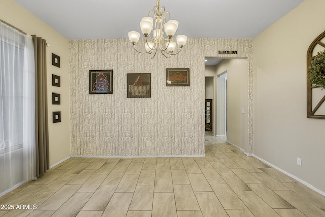 unfurnished dining area with an inviting chandelier, visible vents, baseboards, an accent wall, and wallpapered walls