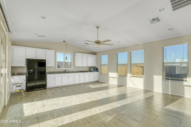 kitchen with stainless steel microwave, a ceiling fan, visible vents, and black fridge