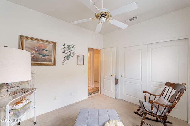 sitting room with ceiling fan and light colored carpet