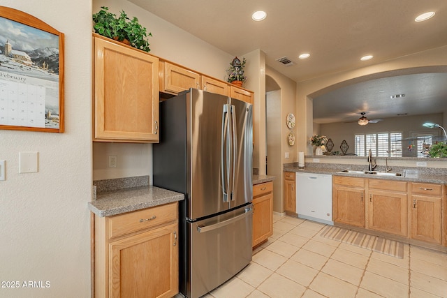 kitchen with sink, stainless steel refrigerator, dishwasher, light tile patterned flooring, and light brown cabinets