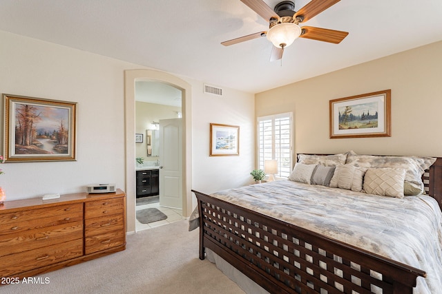 carpeted bedroom featuring ensuite bath and ceiling fan