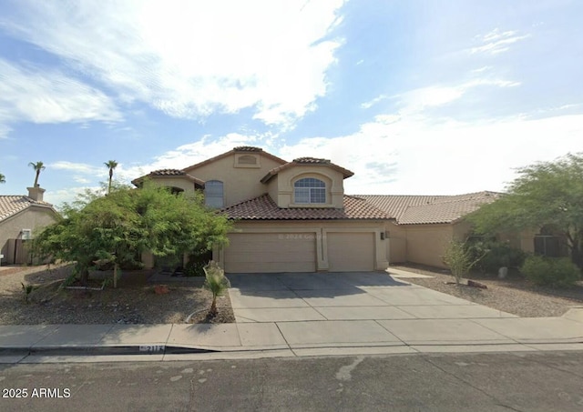 mediterranean / spanish-style home featuring driveway, an attached garage, a tile roof, and stucco siding