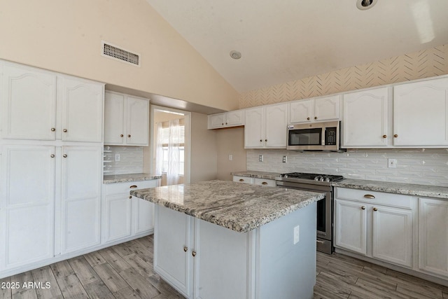 kitchen featuring white cabinetry, appliances with stainless steel finishes, and visible vents