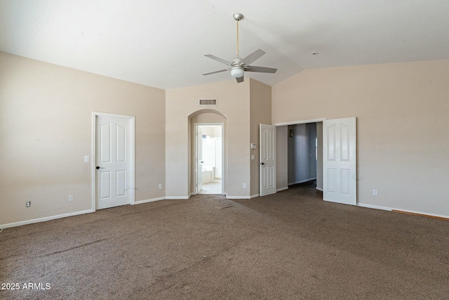 unfurnished bedroom featuring carpet floors, arched walkways, baseboards, and visible vents