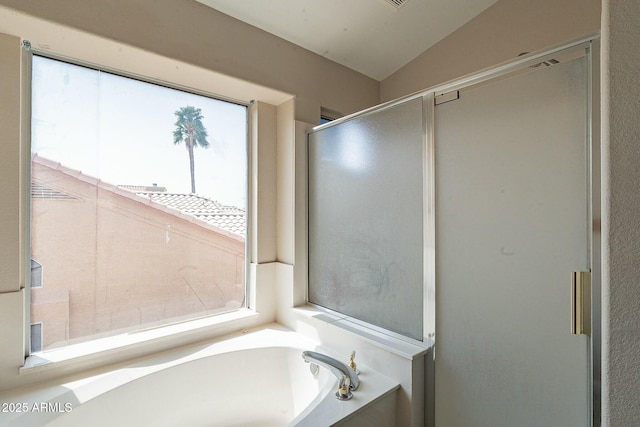 full bathroom featuring a shower with shower door, lofted ceiling, and a bath