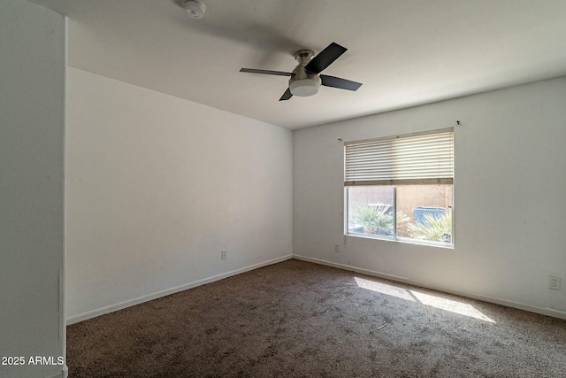 carpeted empty room featuring baseboards and ceiling fan