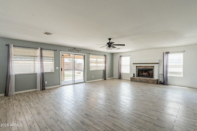unfurnished living room with ceiling fan, visible vents, light wood-style floors, and a wealth of natural light