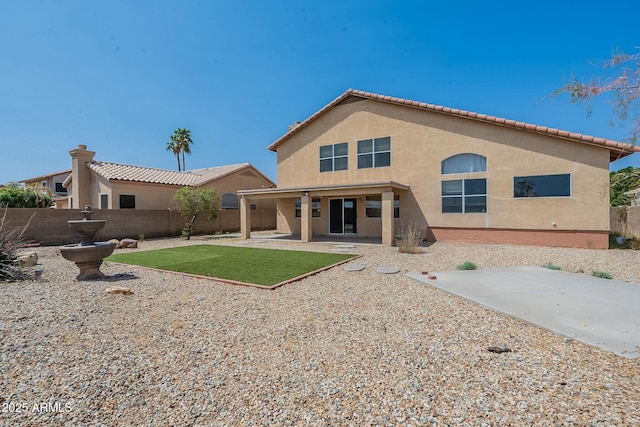 back of house featuring stucco siding, fence, and a patio