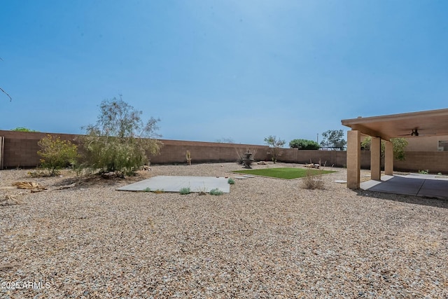 view of yard with a ceiling fan, a fenced backyard, and a patio