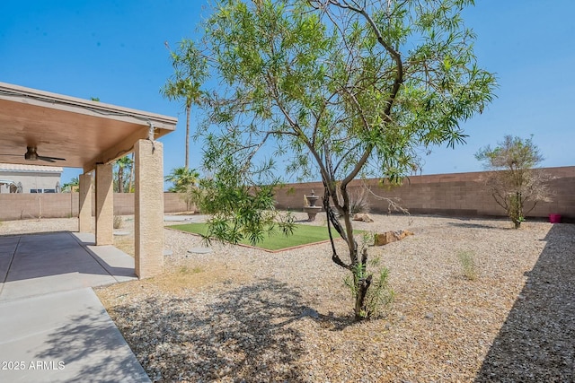 view of yard featuring a fenced backyard, a patio area, and a ceiling fan
