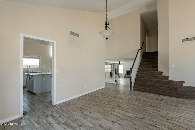 interior space with visible vents, wood finished floors, stairway, and a ceiling fan