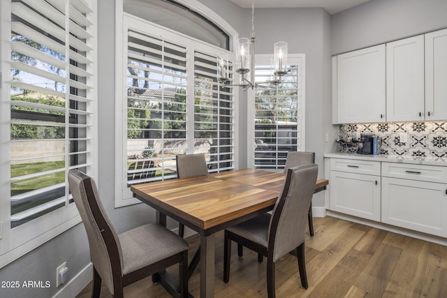 dining area featuring dark hardwood / wood-style floors, a healthy amount of sunlight, and a chandelier