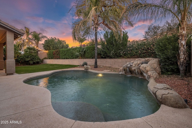 pool at dusk featuring pool water feature