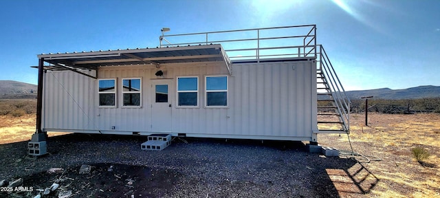 rear view of property featuring stairway and a mountain view