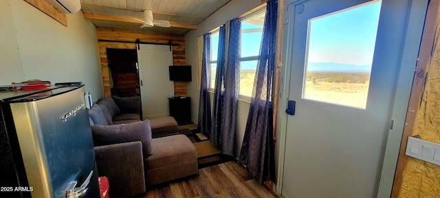 miscellaneous room with a barn door, wood finished floors, and wood ceiling