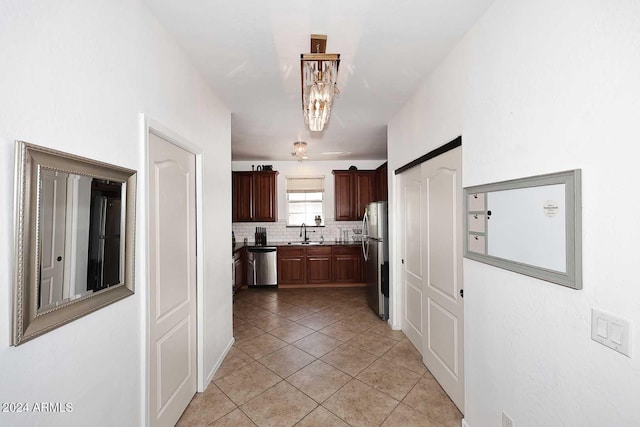 4306 E Tyson St, Gilbert, AZ 85295 - kitchen featuring stainless steel appliances, tasteful backsplash, a sink, an inviting chandelier, and light tile patterned floors