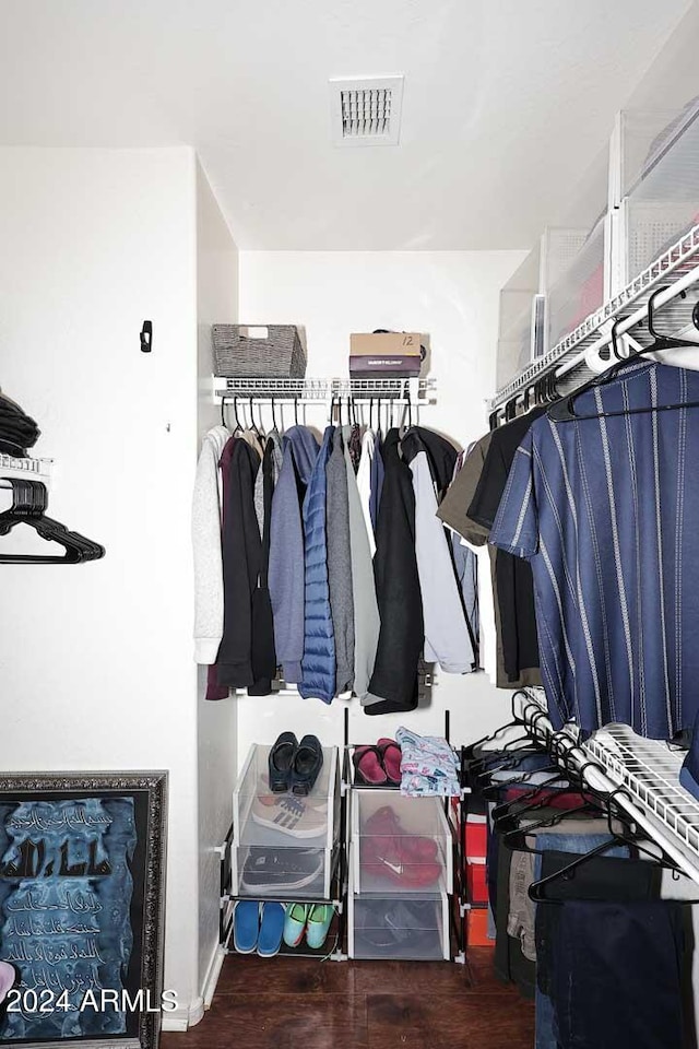 walk in closet with dark wood-type flooring