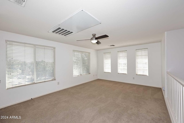 spare room with ceiling fan and light colored carpet