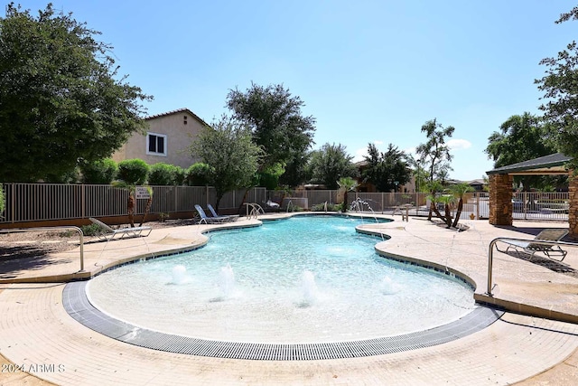 view of swimming pool with pool water feature and a patio