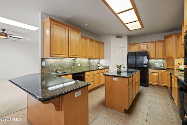 kitchen with visible vents, a center island, a peninsula, black appliances, and a sink