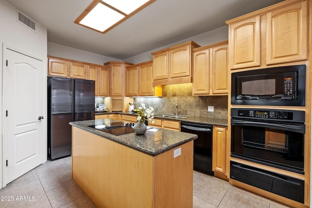 kitchen with light tile patterned floors, visible vents, a sink, black appliances, and a warming drawer