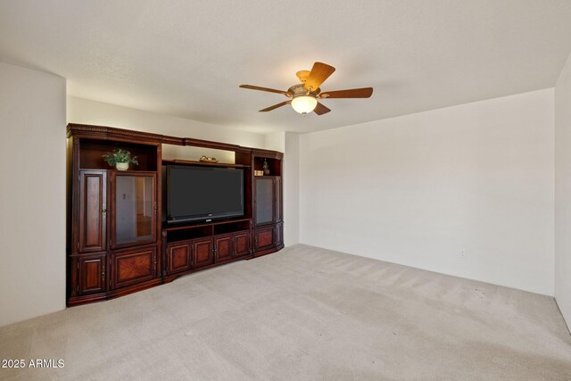 unfurnished living room with a ceiling fan and light colored carpet