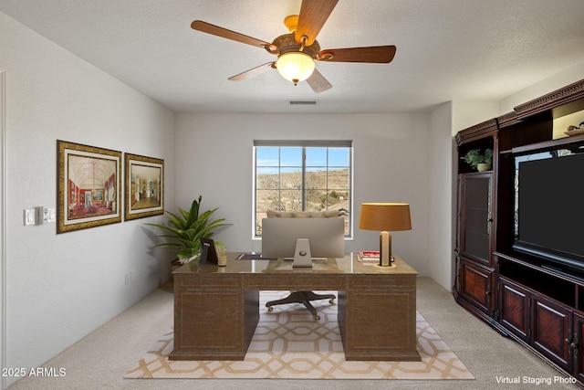 home office with visible vents, light colored carpet, ceiling fan, and a textured ceiling