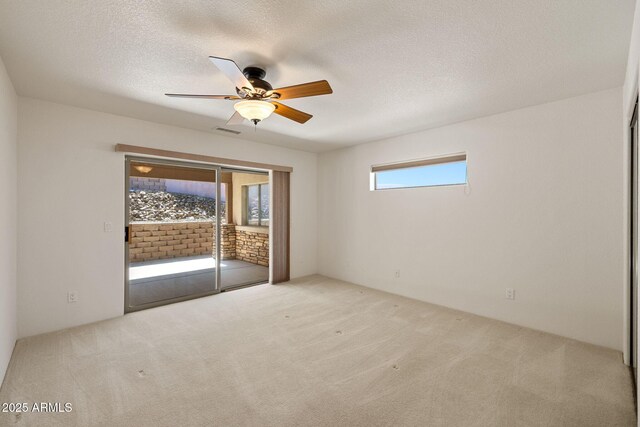 unfurnished bedroom featuring visible vents, access to exterior, a textured ceiling, carpet, and ceiling fan