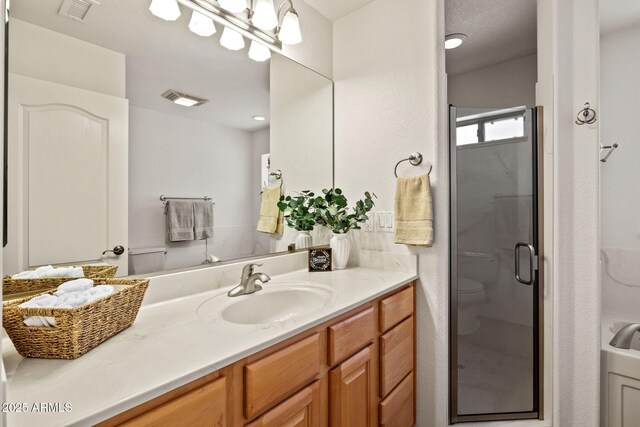 full bath with visible vents, toilet, a stall shower, and vanity