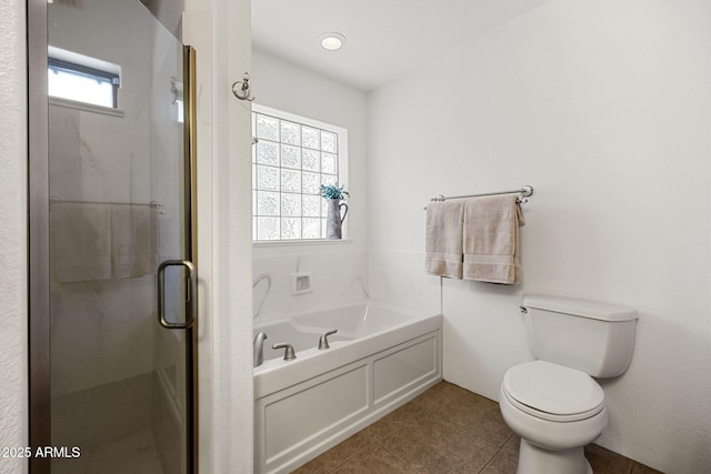 bathroom featuring tile patterned floors, toilet, a stall shower, and a bath