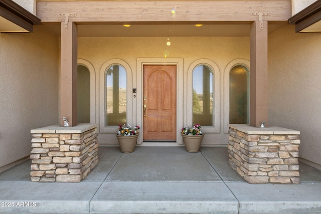 doorway to property with stucco siding and a porch