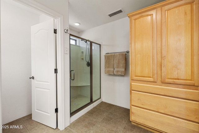 bathroom featuring tile patterned flooring, visible vents, and a stall shower