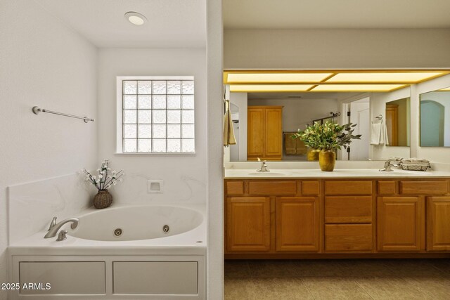 bathroom featuring double vanity, tile patterned floors, a jetted tub, and a sink