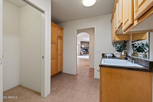 bathroom featuring tile patterned floors, a fireplace, and a sink