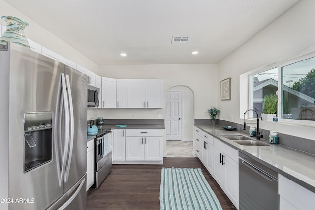 kitchen with white cabinets, dark hardwood / wood-style floors, sink, and stainless steel appliances