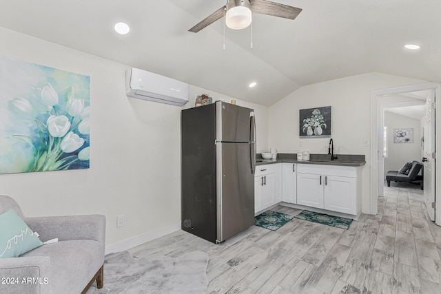 interior space featuring ceiling fan, an AC wall unit, hardwood / wood-style floors, vaulted ceiling, and vanity