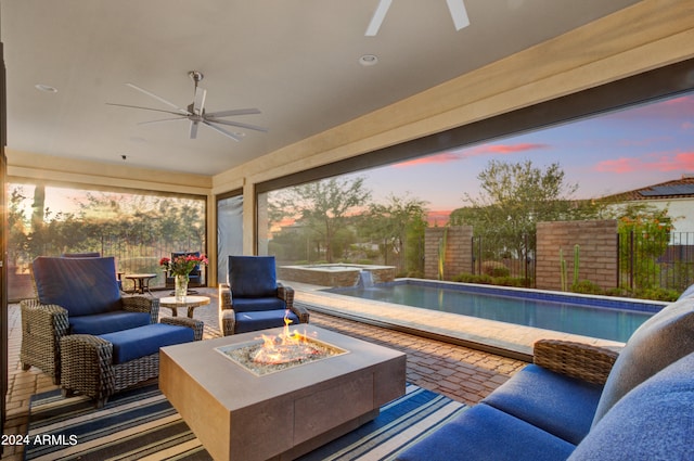 patio terrace at dusk with an outdoor living space with a fire pit, ceiling fan, and a fenced in pool