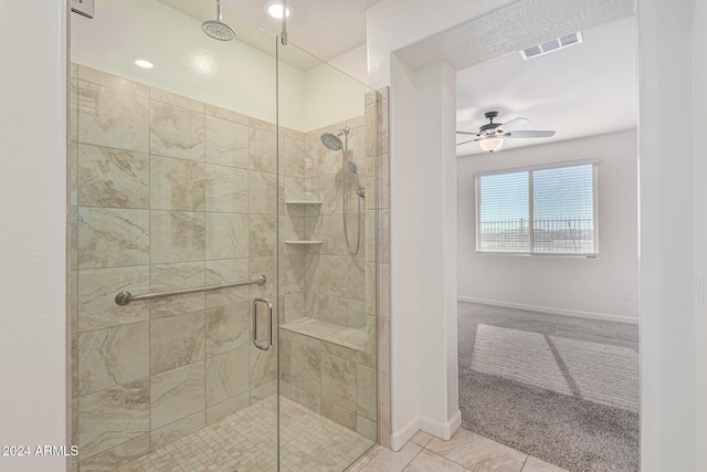 bathroom featuring ceiling fan, tile patterned floors, and a shower with shower door