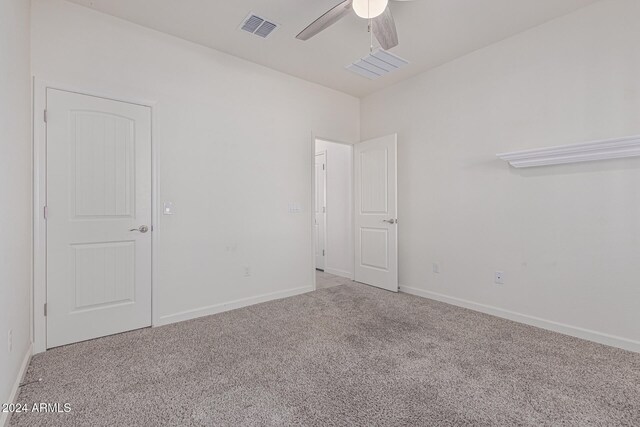 unfurnished room featuring ceiling fan and carpet floors