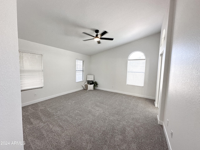 empty room with ceiling fan, carpet floors, and a textured ceiling