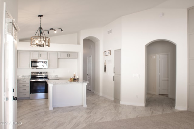 kitchen featuring gray cabinets, light carpet, stainless steel appliances, and decorative light fixtures