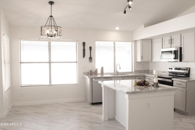 kitchen featuring a center island, sink, stainless steel appliances, and plenty of natural light