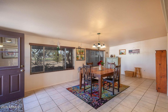 tiled dining room with a chandelier and a textured ceiling