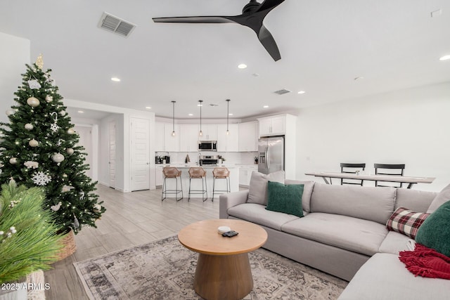 living room featuring light wood-type flooring and ceiling fan