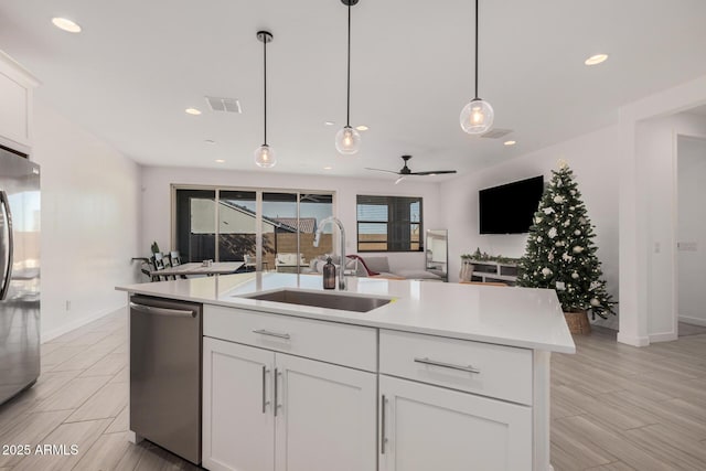 kitchen featuring sink, white cabinets, a center island with sink, and appliances with stainless steel finishes