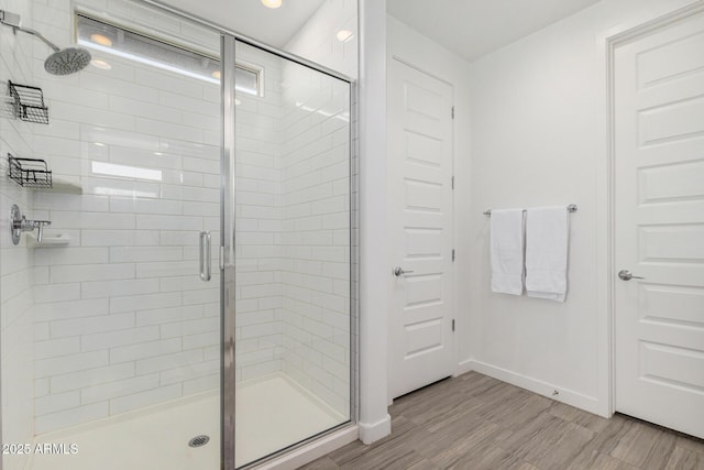 bathroom featuring an enclosed shower and hardwood / wood-style flooring