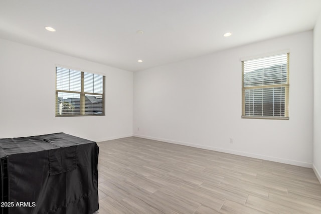 unfurnished room with a healthy amount of sunlight and light hardwood / wood-style flooring