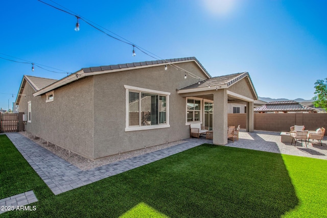 back of property with a lawn, outdoor lounge area, and a patio